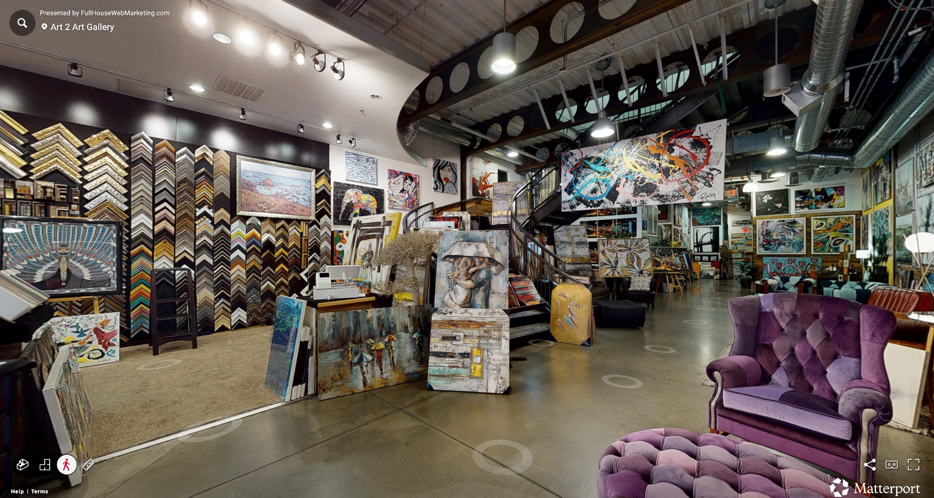 Interior of the ART 2 art Gallery and Framing Center with frame samples, paintings, and lounge seating.